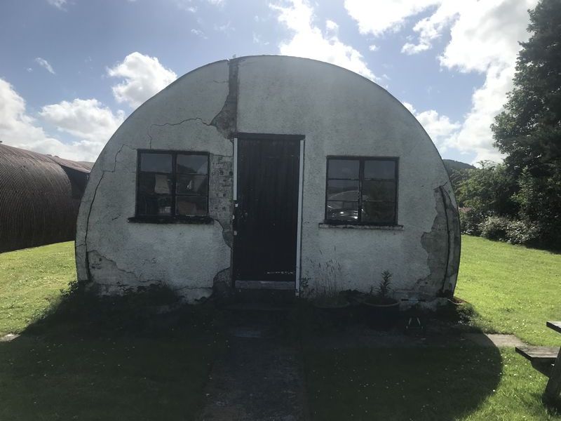 Nissen hut gable end showing cracked render and structural movement