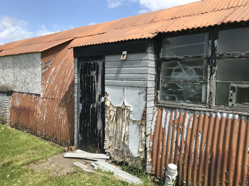 Nissen hut gable end showing severe deterioration of paintwork and woodwork